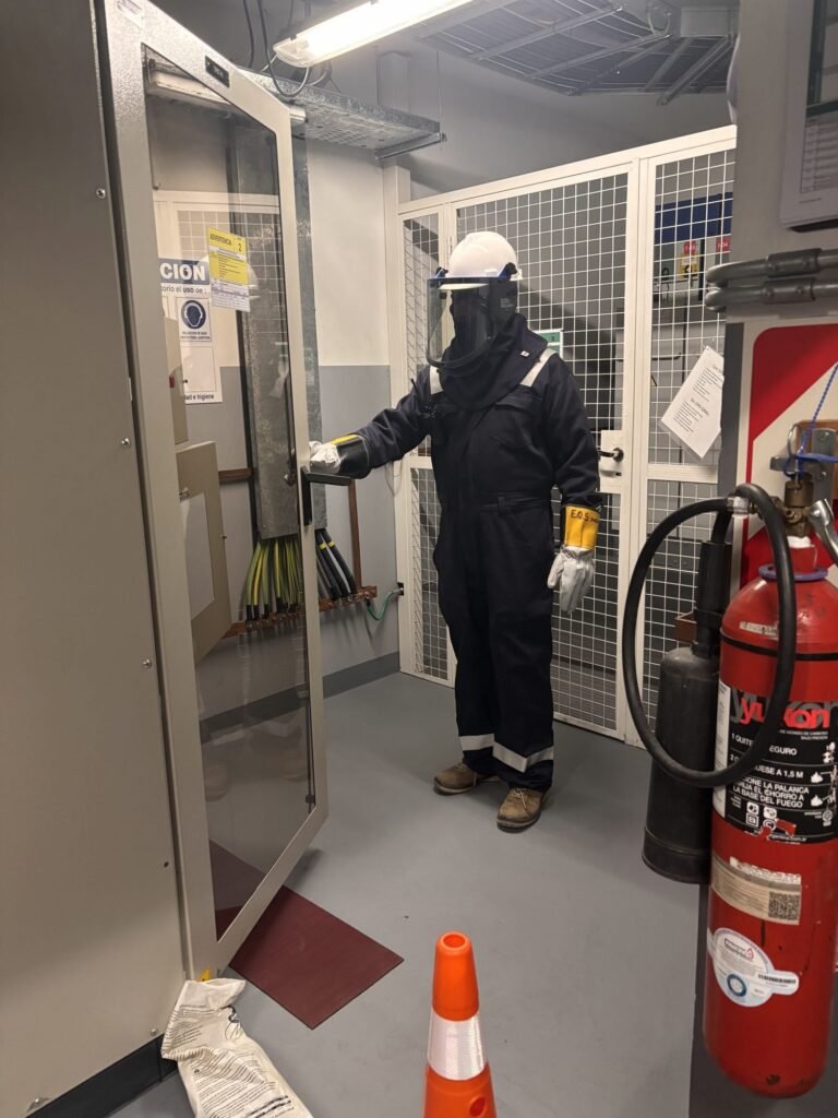 Técnico con EPP para arco eléctrico frente a tablero